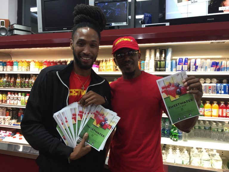 Mark Schand (at right) and his son, Quentin, who is passing out flyers for the new smoothie cafe.