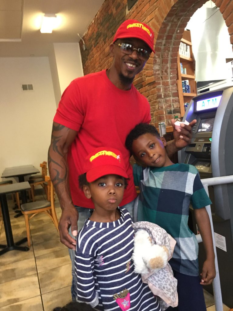 Mark Schand with his grandchildren, who are helping out at his smoothie cafe.